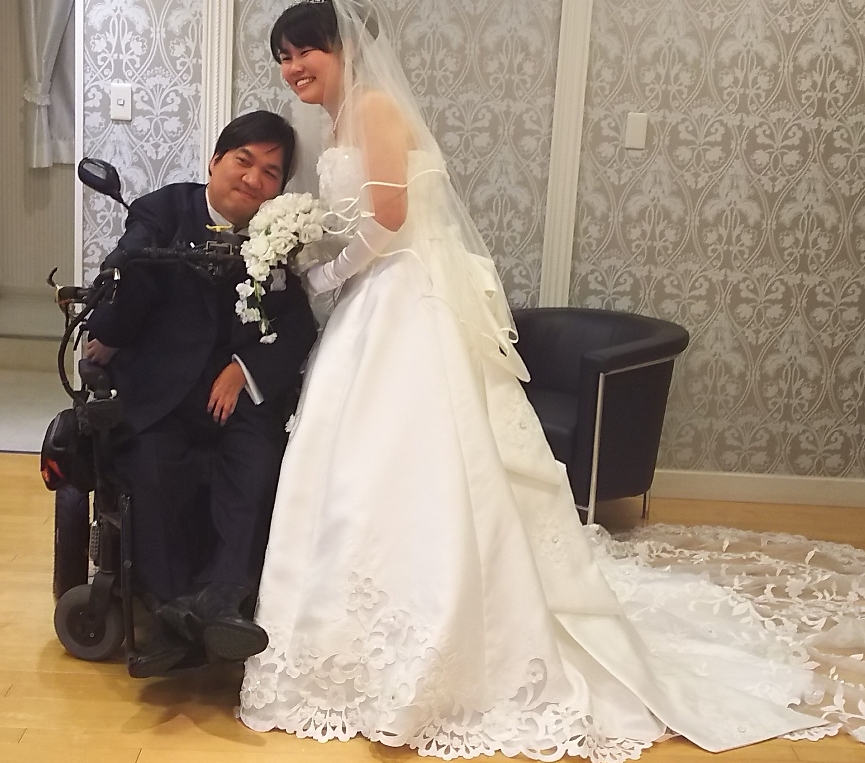 車椅子の新郎と新婦の写真