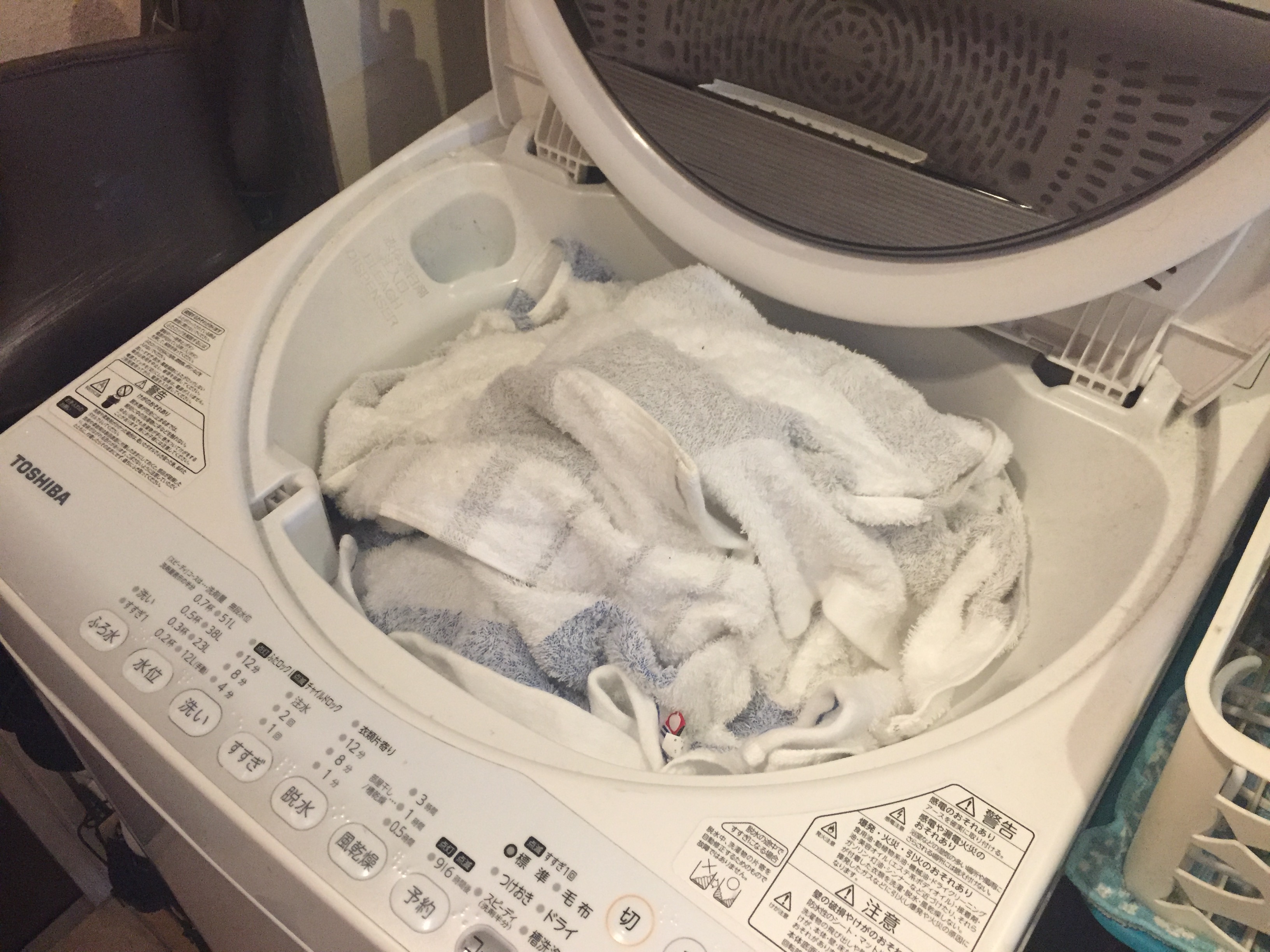 溜め込んだ洗濯物がぎっしり詰まっている洗濯機の写真イメージ