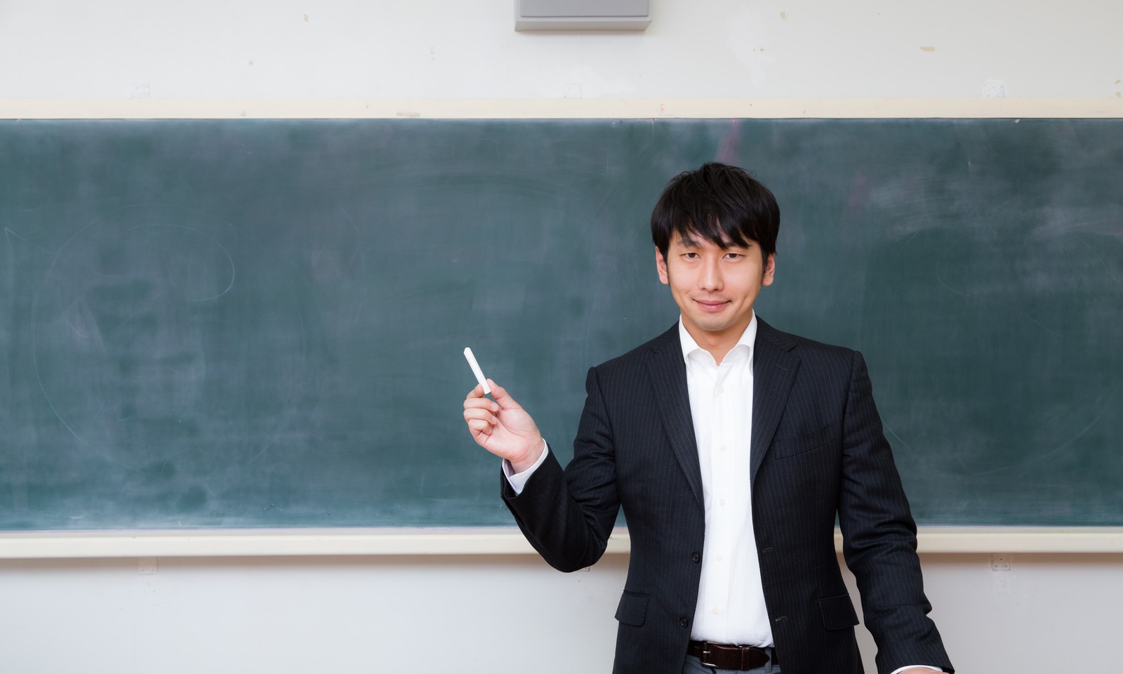 黒板の前に立つ男性