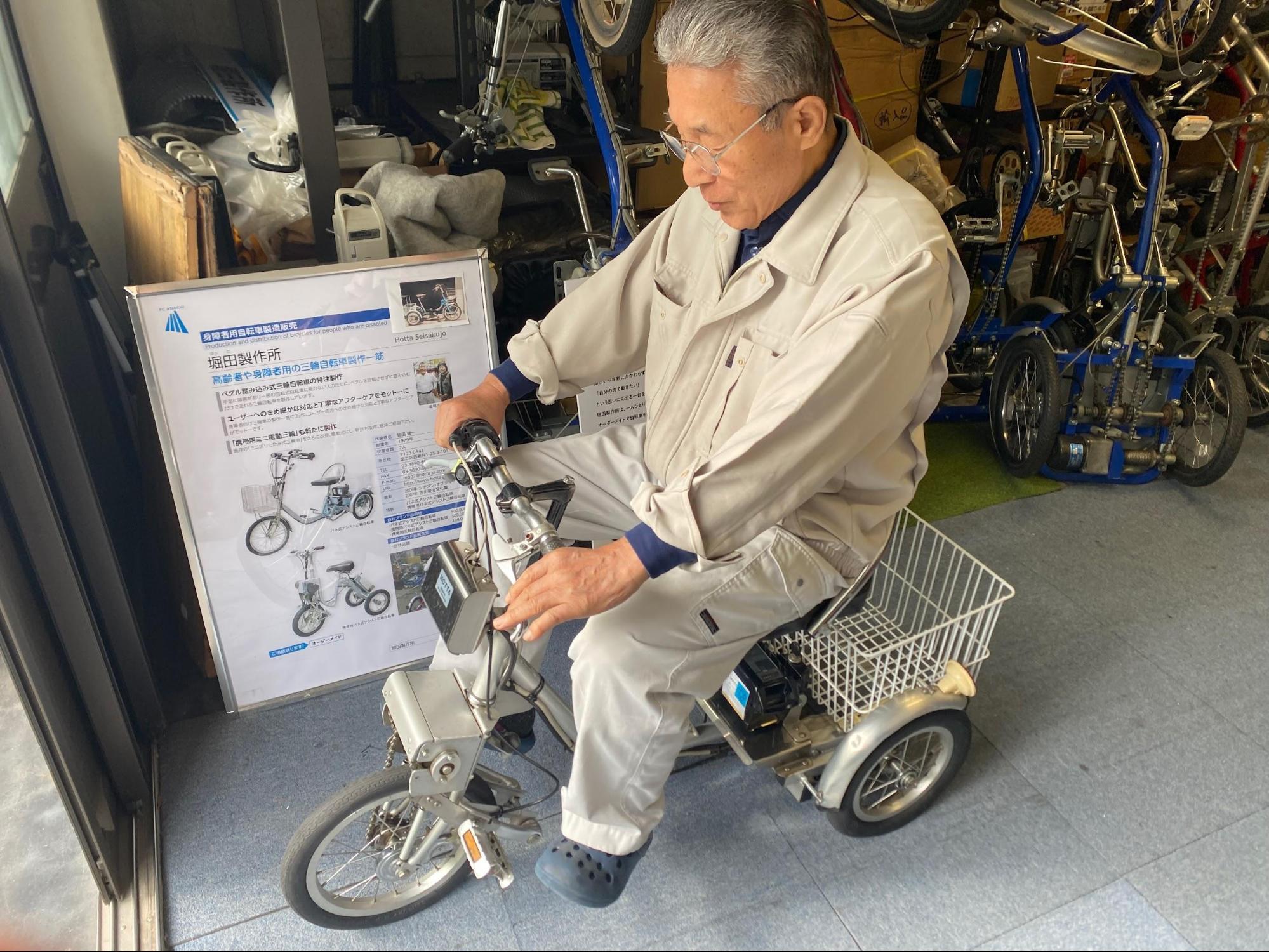 最新の電動アシスト付き自転車に乗ってみる堀田さん。